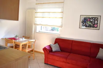 a living room with a red couch and a table at Ferienwohnung Pippohof in Appiano sulla Strada del Vino