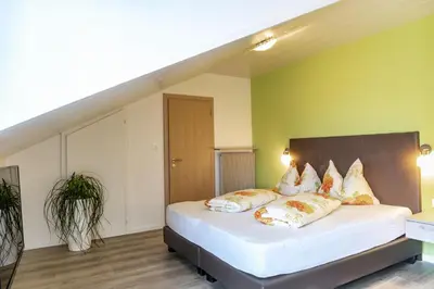 a bedroom with a large white bed with pillows at Garni Wieterer in Terlano
