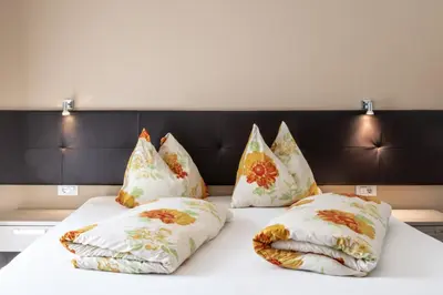 a bed with four pillows on top of it at Garni Wieterer in Terlano