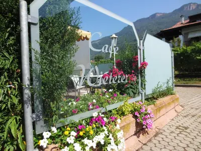 a garden of flowers in front of a sign at Garni Wieterer in Terlano