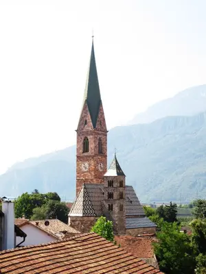 a church with a clock tower on top of a roof at Garni Wieterer in Terlano