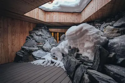 a building with snow on the outside of it at Tenne Chalets in Racines