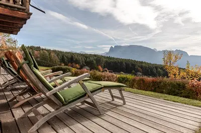 a couple of chairs sitting on a wooden deck at Haus Sophie in Longomoso