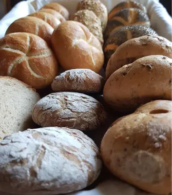 a pile of different types of bread in a basket at Pension Gartscheid in Lana