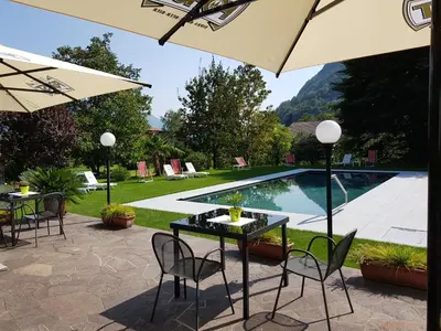 a patio with a table and chairs and a pool at Pension Gartscheid in Lana