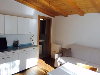 a living room with a couch and a kitchen at La terrazza gardenese in Santa Cristina in Val Gardena