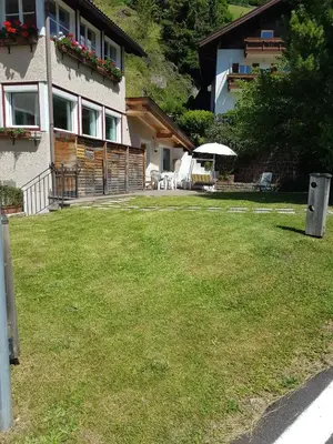 a house with a lawn in front of a building at La terrazza gardenese in Santa Cristina in Val Gardena
