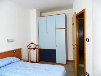 a bedroom with a bed and a large cabinet at Appartamento 