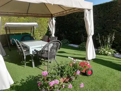 a table and chairs under an umbrella in a garden at Appartamento 