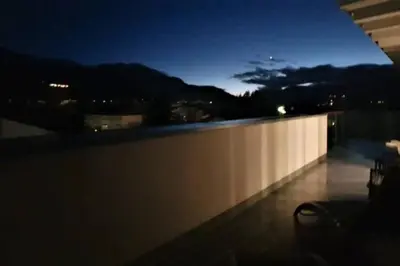 a view of a balcony at night from a building at Gardenpark Loft in Ora/Auer