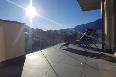 a chair sitting on top of a balcony with a view at Gardenpark Loft in Ora/Auer