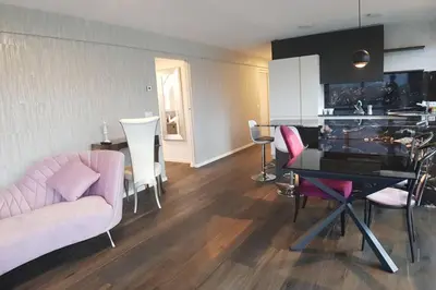 a living room with a pink couch and a table at Gardenpark Loft in Ora/Auer