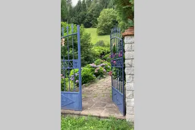 an entrance to a garden with blue gates at Paola’s Country Home - Vanoi Primiero Trentino in Canale San Bovo