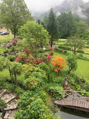 a garden with colorful flowers and a bridge at Paola’s Country Home - Vanoi Primiero Trentino in Canale San Bovo