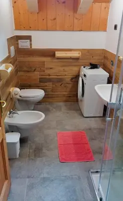 a bathroom with two toilets and a sink at La Majon in Colle Santa Lucia