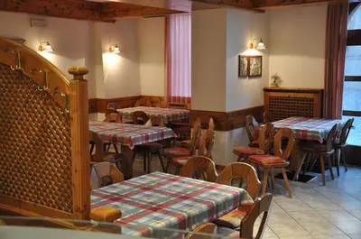 a restaurant with tables and chairs in a room at Albergo Dolomiti in Capriana