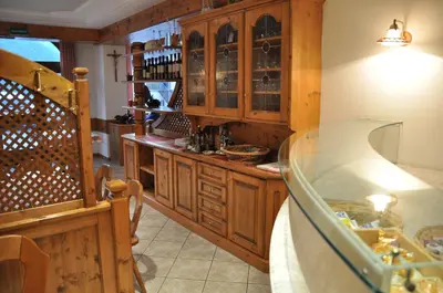 a kitchen with wooden cabinets and a glass counter at Albergo Dolomiti in Capriana