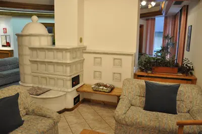 a living room with two chairs and a fireplace at Albergo Dolomiti in Capriana
