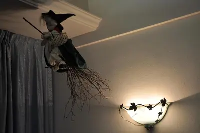 a witch hanging from the ceiling next to a light at Albergo Dolomiti in Capriana