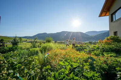 two people walking in a garden with flowers at Rösslhof in Caldaro