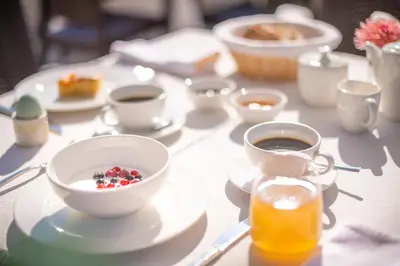 a table with a cup of coffee and a bowl of food at Rösslhof in Caldaro