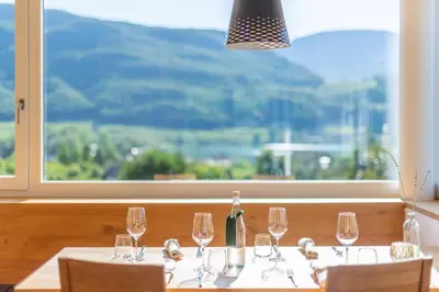 a table with glasses and a bottle of wine at Rösslhof in Caldaro