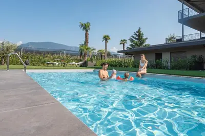 a group of people sitting in a swimming pool at Paulsner Feldhof in Appiano sulla Strada del Vino