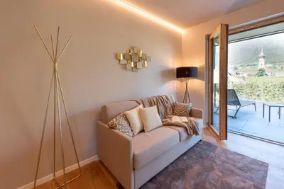 a living room with a couch and a lamp at Paulsner Feldhof in Appiano sulla Strada del Vino