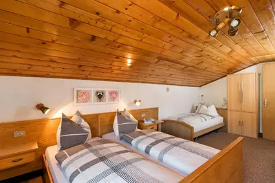 two beds in a room with wooden ceilings at Col Dala Vara in San Cassiano