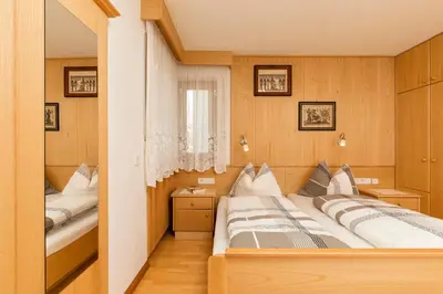 a bedroom with two beds and a mirror at Col Dala Vara in San Cassiano