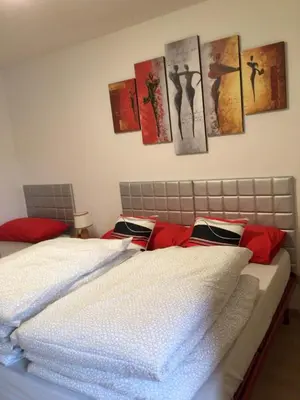 a bedroom with two beds and paintings on the wall at Appartamento Nemo in Alleghe