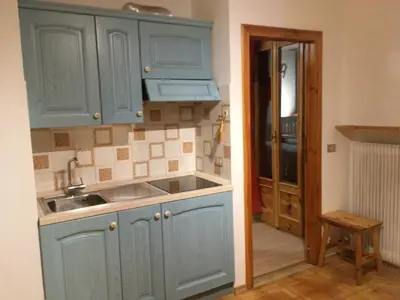 a kitchen with blue cabinets and a sink at Appartamento Nemo in Alleghe