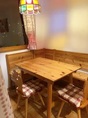 a wooden table with two chairs and a lamp at Appartamento Nemo in Alleghe