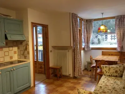 a kitchen with green cabinets and a table and a window at Appartamento Nemo in Alleghe