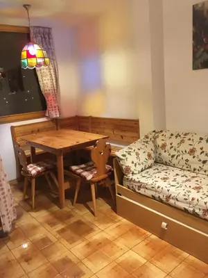a living room with a table and a couch at Appartamento Nemo in Alleghe