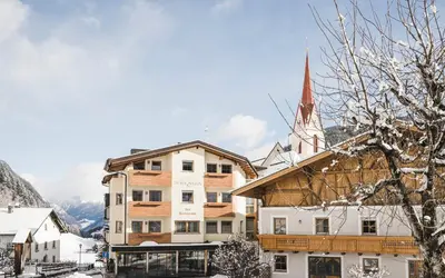 a building with a church in the snow at Hotel Schölzhorn Superior in Racines