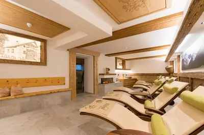 a row of chairs in a room with wooden ceilings at Hotel Maibad in Vipiteno