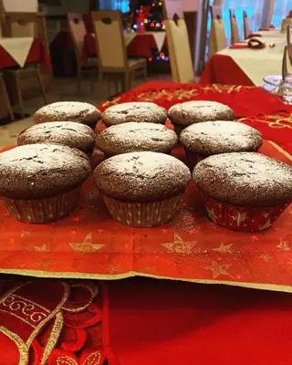 a table topped with cupcakes with powdered sugar on top at Affittacamere Dolce Sogno in Coredo