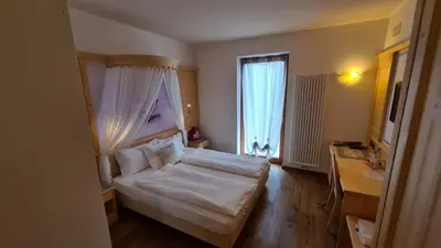 a bedroom with a bed and a window at Affittacamere Dolce Sogno in Coredo
