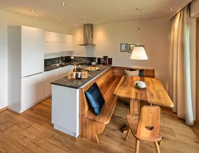 a kitchen with a wooden table and a dining room at Weingut Eichenstein in Merano
