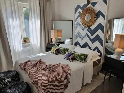 a bedroom with a bed with pillows and a mirror at THE MIRROR GUESTHOUSE - TERME MERANO in Merano