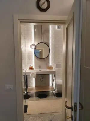 a bathroom with a sink and a mirror at THE MIRROR GUESTHOUSE - TERME MERANO in Merano