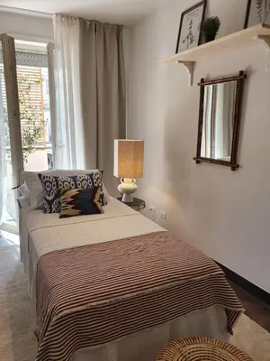 a bedroom with a bed and a lamp and a window at THE MIRROR GUESTHOUSE - TERME MERANO in Merano