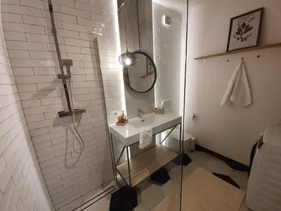 a white bathroom with a sink and a shower at THE MIRROR GUESTHOUSE - TERME MERANO in Merano