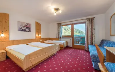 a hotel room with two beds and a window at Hotel Kaserhof in Valles
