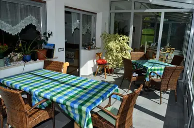 a patio with two tables and wicker chairs at Pension Pichler in Chienes