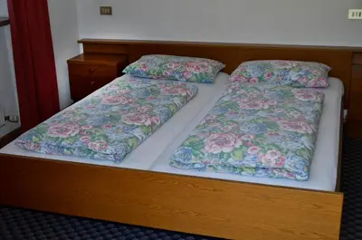 two beds with pillows on them in a bedroom at Pension Pichler in Chienes