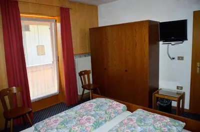 a hotel room with a bed and a window at Pension Pichler in Chienes
