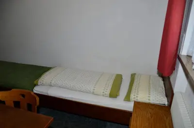 a small bed with two pillows on it at Pension Pichler in Chienes