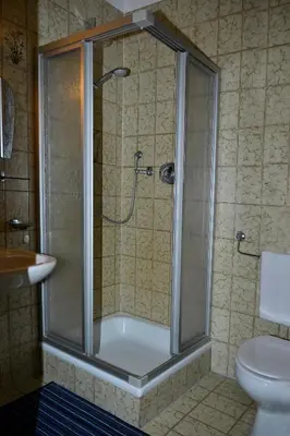 a shower with a glass door in a bathroom at Pension Pichler in Chienes